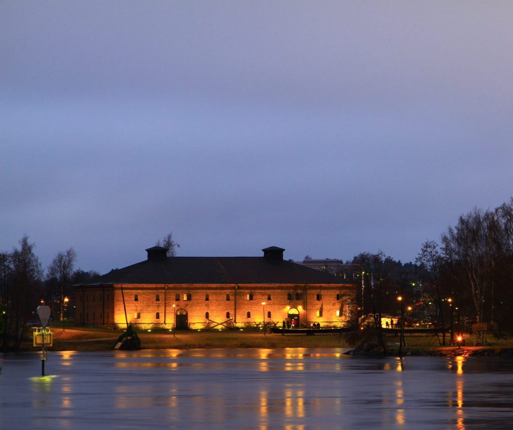 Savonlinna Museum Red brick warehouse building in the evening light. Water in front.