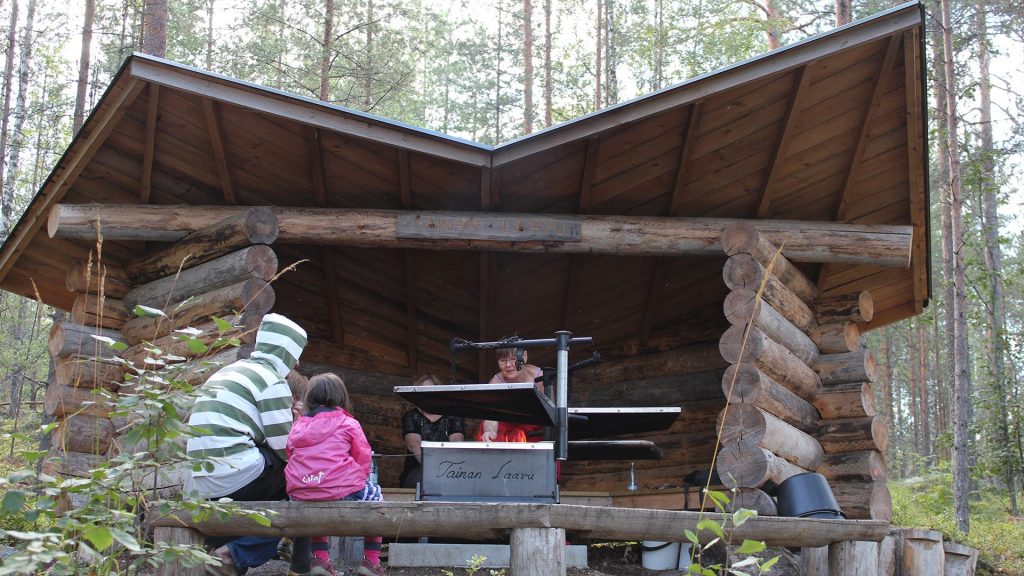 Taina shelter with family around the fireplace.